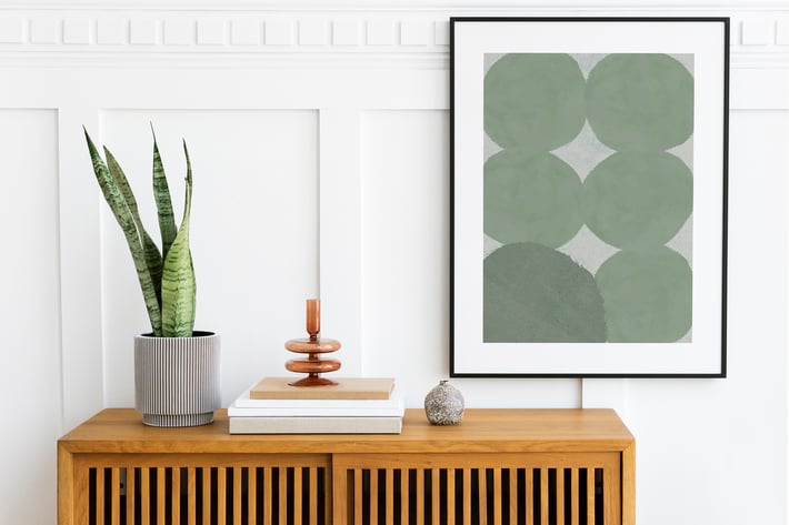 Picture frame mockup hanging above wooden cabinet