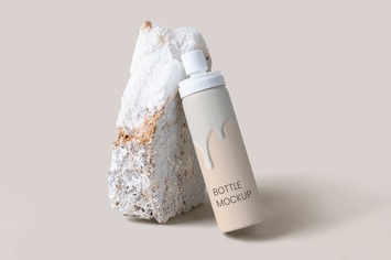 White spray bottle psd mockup against a rock