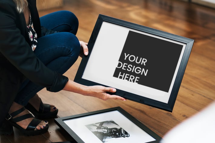 Woman holding an image frame Mockup