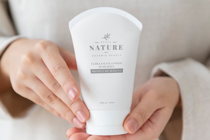 Woman holding a facial cream tube mockup