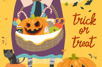 Girl holding basket with pumpkin and sweets.