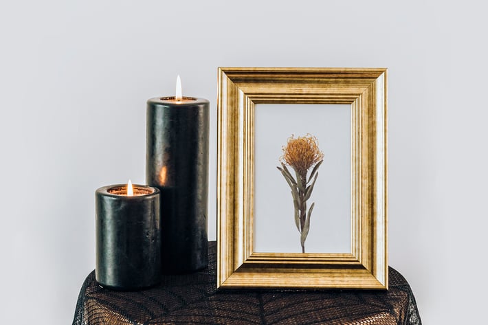 Golden frame mockup by the black pillar candles